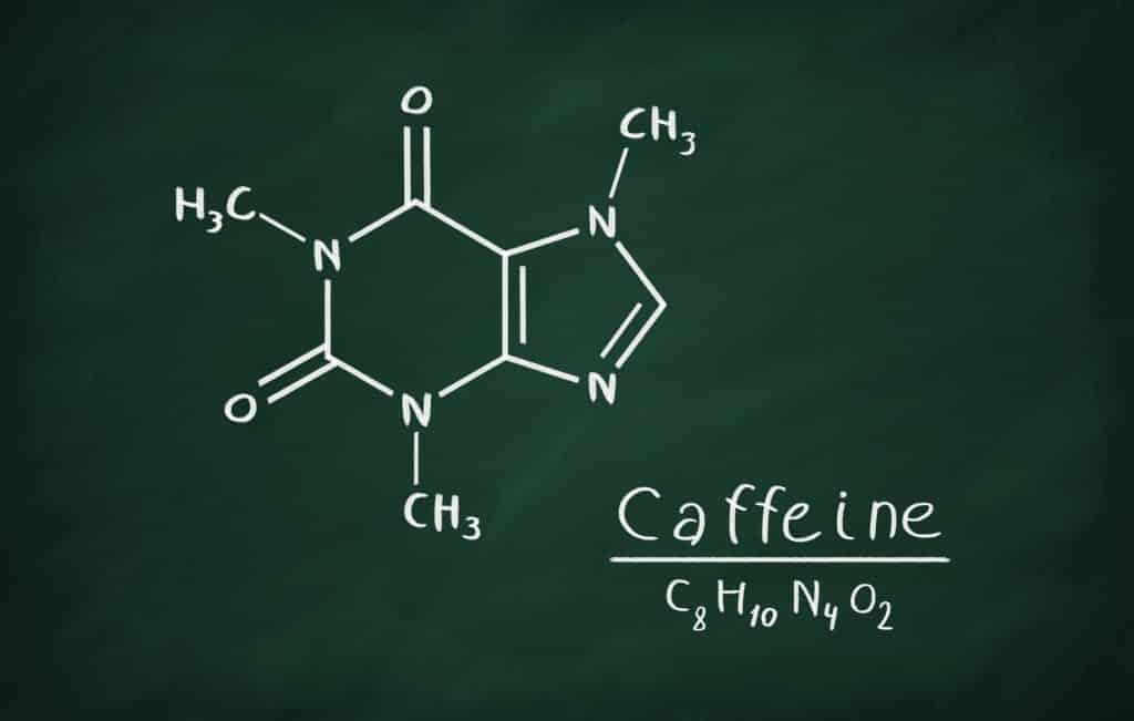 Caffeine molecule written with crayon on a blackboard